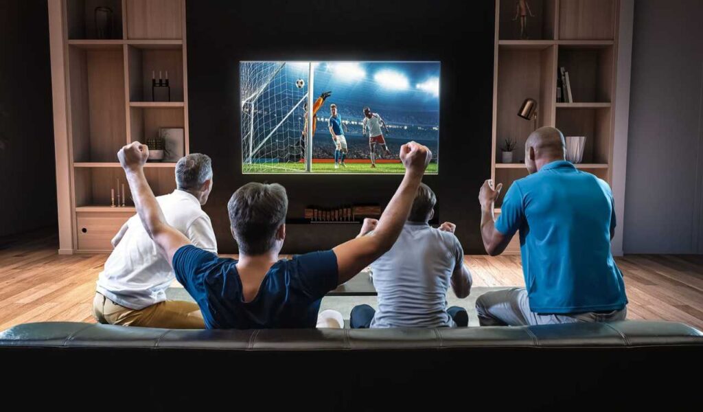 Imagem de pessoas assistindo à uma partida de futebol na televisão (Foto: Reprodução/Internet)